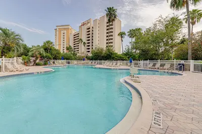 a swimming pool in a resort with palm trees and buildings at Cozy Lakeview Getaway Near Universal Studios 2602 in Orlando
