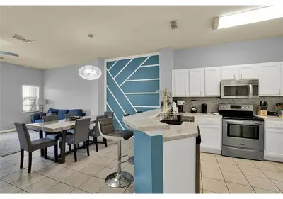 a kitchen and dining room with a table and chairs at 3157 YL - Encantada Serenity Retreat Elegant Villa Close to Disney in Kissimmee