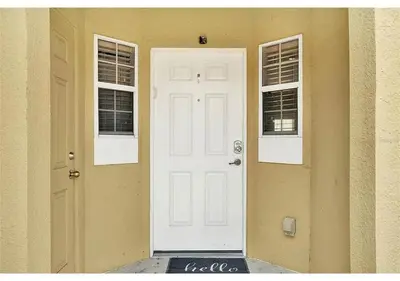 a white door on a house with two windows at 3157 YL - Encantada Serenity Retreat Elegant Villa Close to Disney in Kissimmee