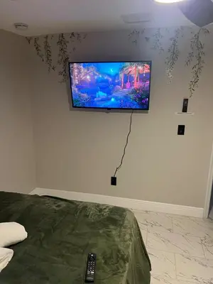 a flat screen tv on the wall of a bedroom at The Secret Garden Games Getaway in Orlando