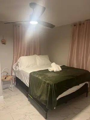 a bedroom with a bed with a ceiling fan at The Secret Garden Games Getaway in Orlando