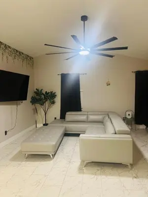 a living room with two white couches and a television at The Secret Garden Games Getaway in Orlando