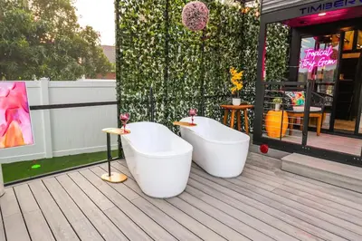 two bath tubs sitting on a deck next to a building at FunTropicalTinyGemUCF in Orlando