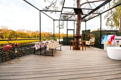 a pavilion with a table and chairs on a wooden deck at FunTropicalTinyGemUCF in Orlando