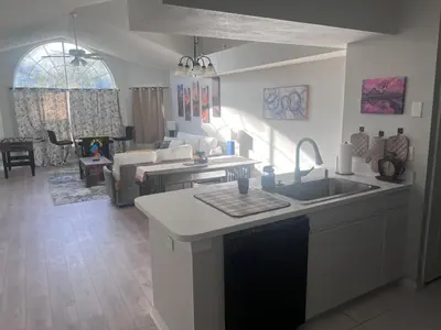 a kitchen with a sink and a living room at 3-BR Condo near Disney & Universal in Kissimmee