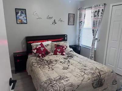 a bedroom with a bed with a black and white comforter at 3-BR Condo near Disney & Universal in Kissimmee
