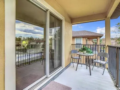 a patio with a table and chairs on a balcony at Family Getaway: 4BR Townhome by Old Town in Orlando