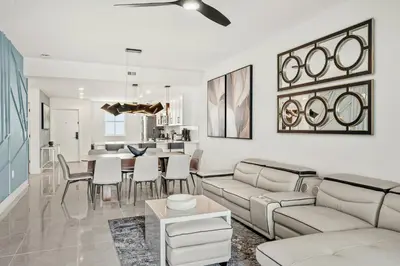 a living room with white furniture and a dining room at Villatel Orlando Resort, Apartments by Marriott Bonvoy in Orlando