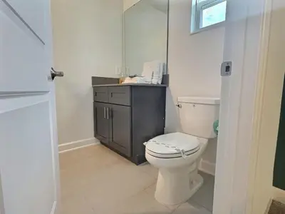 a bathroom with a white toilet and a sink at 5BR c/Piscina Privada | Luxo em Storey Lake in Kissimmee