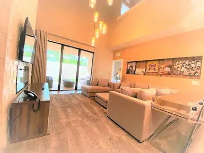 a large living room with a couch and a television at Casa 4Q Elegante Perto da Disney – Magic Village in Orlando