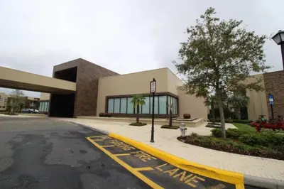 a building with a parking lot next to a street at 7639- Encantadora Casa com 3 Suítes no Magic Village Yards, Perto da Disney e da Rota 192 in Orlando