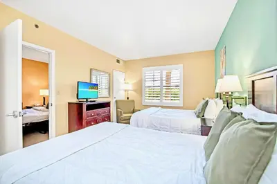 a hotel room with two beds and a television at Two Queen Beds - Pool Hot Tub Close to Disney in Orlando