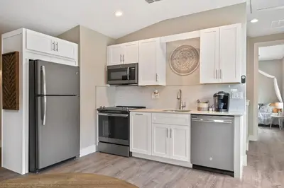 a kitchen with white cabinets and stainless steel appliances at Great Outdoor Area in Orlando