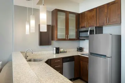 a kitchen with a white refrigerator and wooden cabinets at Residence Inn by Marriott Orlando Downtown in Orlando