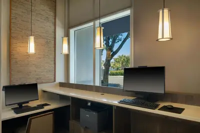 two computer monitors on a desk with a window at Residence Inn by Marriott Orlando Downtown in Orlando