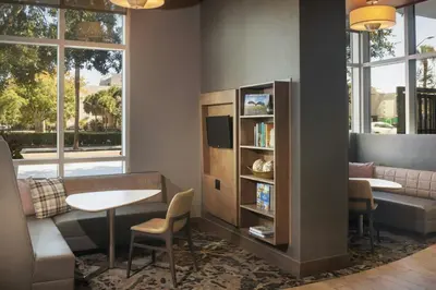 a living room with a table and a book shelf at Residence Inn by Marriott Orlando Downtown in Orlando