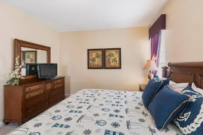 a bedroom with a bed with a television and a dresser at Aruba Palms Villa Near Disney & Attractions in Kissimmee