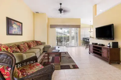 a living room with a couch and a flat screen tv at Aruba Palms Villa Near Disney & Attractions in Kissimmee