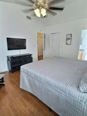 a bedroom with a bed and a flat screen tv at Apartamento 3 Quartos a Minutos da Disney in Kissimmee