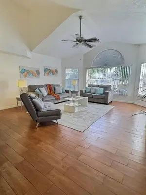 a living room with two couches and a ceiling fan at Apartamento 3 Quartos a Minutos da Disney in Kissimmee