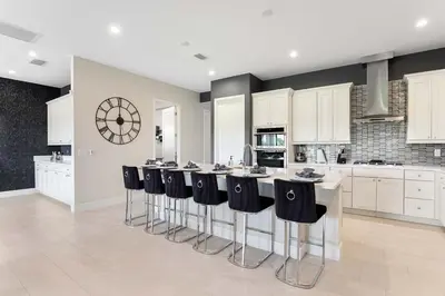 a kitchen with a large island with bar stools at The Nicklaus View Haven-TB007 in Orlando