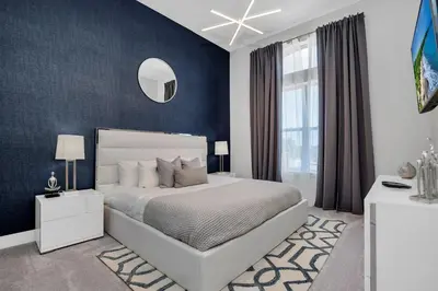 a bedroom with a white bed and a blue wall at The Luxurious Bear's Den Estate-TB009 in Orlando