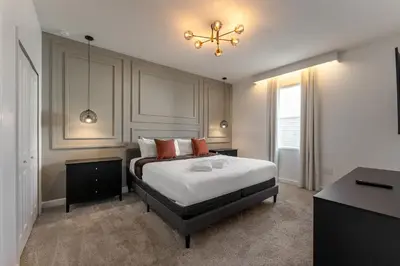 a bedroom with a bed and a chandelier at 2858 Storey Lake brand new 19guests pool game room in Kissimmee