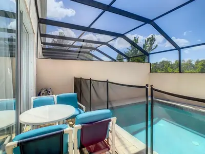 a patio with a table and chairs next to a swimming pool at Celtic Palms: Private Pool & Near Disney Magic in Kissimmee