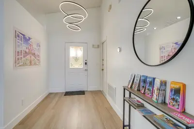 a hallway with a mirror and a shelf with books at 6 Mi to Disney World Home with Large Yard! in Orlando