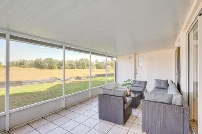 a screened in porch with two couches and a table at 6 Mi to Disney World Home with Large Yard! in Orlando