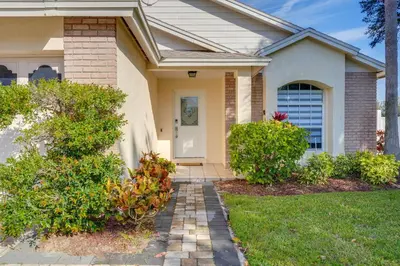 a house with a pathway leading to the front door at 6 Mi to Disney World Home with Large Yard! in Orlando