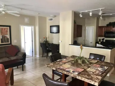 a living room and kitchen with a table and chairs at Cane Island Resort 2BR Condo, Close to Attractions in Kissimmee