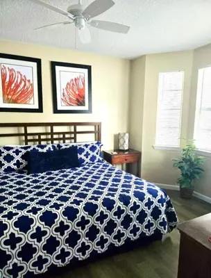 a bedroom with a bed and a ceiling fan at Cane Island Resort 2BR Condo, Close to Attractions in Kissimmee
