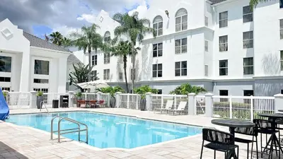 a swimming pool in front of a building at Montreal Suites Orlando in Orlando