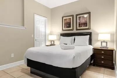 a bedroom with a large white bed with two lamps at Summer Fun Starts Here - Townhome by Disney! in Orlando