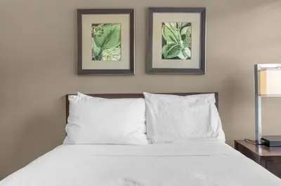a bedroom with a bed with two pictures on the wall at Summer Fun Starts Here - Townhome by Disney! in Orlando