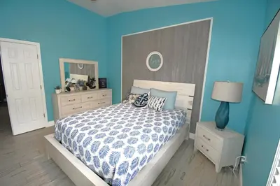 a bedroom with a bed and a blue wall at Best deal on Windsor Palms South facing pool in Kissimmee