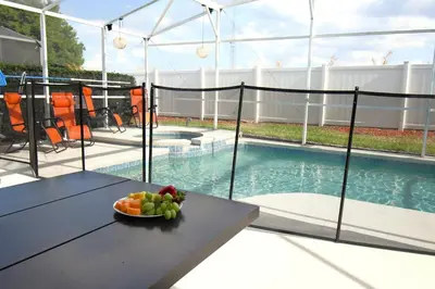 a bowl of fruit on a table next to a swimming pool at Best deal on Windsor Palms South facing pool in Kissimmee