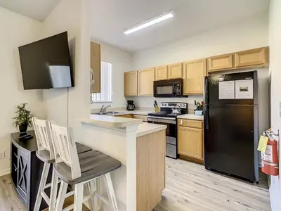 a kitchen with a black refrigerator and wooden cabinets at Old Town and Food trucks around the corner in Orlando