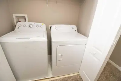a small kitchen with a white refrigerator and a washer and dryer at Great deal townhome on Paradise Palms in Kissimmee
