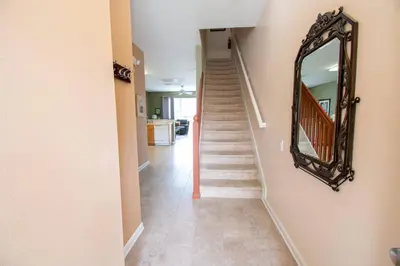 a hallway with a mirror on the wall and a staircase at Great place to stay close to Disney Parks in Kissimmee