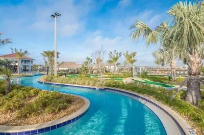 a pool at a resort with blue water and palm trees at Serene Rhyme Escape in Kissimmee