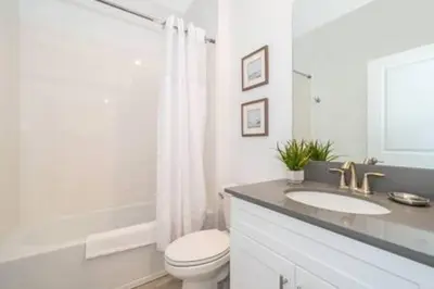 a white bathroom with a toilet and a sink at Serene Rhyme Escape in Kissimmee