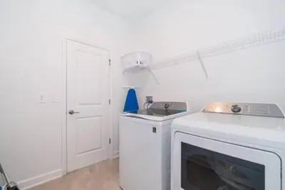 a white kitchen with a stove and a dishwasher at Serene Rhyme Escape in Kissimmee