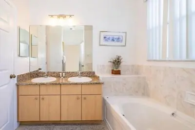 a bathroom with two sinks and a bath tub at Ruby Reds Escape in Kissimmee