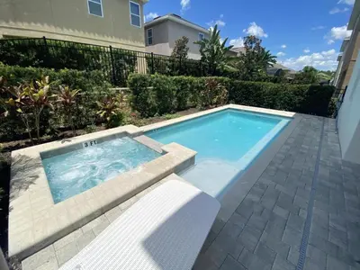 a swimming pool with a bench next to a house at Elegant Family Home | Pool, Spa & Themed Rooms in Orlando