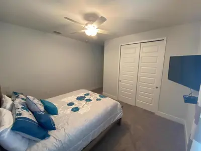 a bedroom with a bed with blue pillows on it at Elegant Family Home | Pool, Spa & Themed Rooms in Orlando