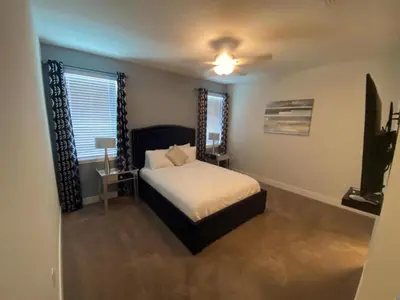 a bedroom with a bed and a ceiling fan at Elegant Family Home | Pool, Spa & Themed Rooms in Orlando