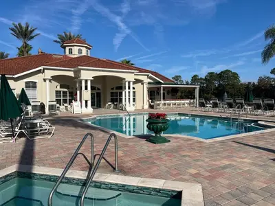 a swimming pool in front of a house with a building at Four Seasons Vacation, heated Pool, 3mile 2 Disney in Kissimmee