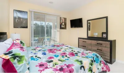 a bedroom with a bed and a dresser and a mirror at Emerald Island Getaway – Sleeps 13! in Kissimmee